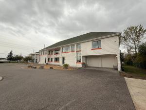 a large white house with a parking lot at Howard Johnson by Wyndham Brampton in Brampton