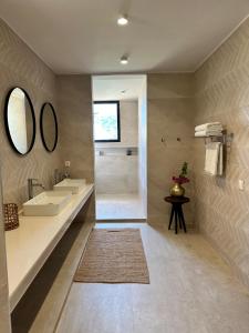 a bathroom with a sink and a shower and a mirror at Aerys Village in Somone