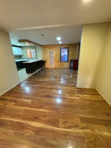 an empty room with wood floors and a piano at Alojamiento casa in Temuco