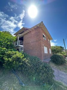 una casa di mattoni con il sole nel cielo di Juana Pinamar a Ostende