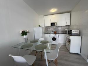 a kitchen with a glass table and white appliances at The White Pearl Marbella in Marbella