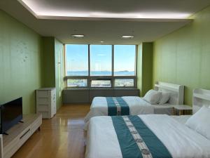 una habitación de hotel con dos camas y un televisor de pantalla plana en 温馨小屋Cozy House, en Incheon