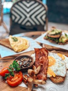 a wooden table with a plate of breakfast food at Casa Coco in Nusa Lembongan