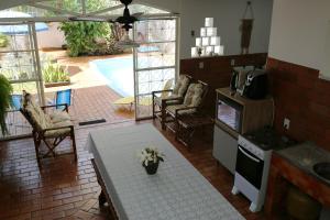 a kitchen with a table and chairs and a patio at Casa com PISCINA no CENTRO - Estacionamento PRIVATIVO - 650m do Shopping JL in Foz do Iguaçu