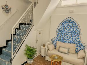 a stairway with a couch and a blue and white wall at Chambre Lumineuse avec Vue Ruelle Bleue et Terrasse in Chefchaouene