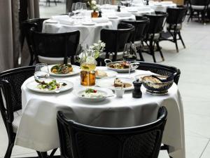 a table in a restaurant with plates of food on it at Domaine de la Reine Margot Paris-Issy - MGallery Collection in Issy-les-Moulineaux