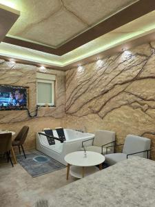 新帕扎尔Dior Apartment Novi Pazar - Luxury Jacuzzi Suite的房间里有浴缸，电视机嵌在石墙上。