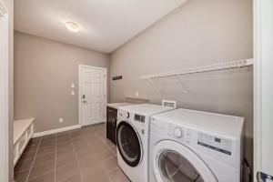 艾尔德里Waterfront Home, Fireplace, 90 min to Banff的配有洗衣机和烘干机的洗衣房
