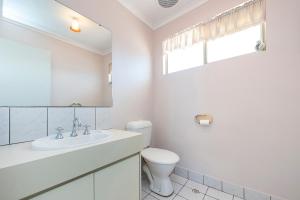 Un baño blanco con inodoro y lavabo. en Shore Beats Work, en Guilderton 16 fotos más