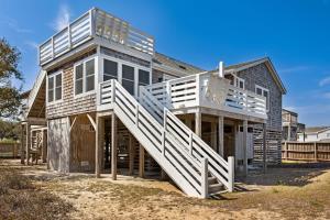 une grande maison avec une rampe d'escalier blanche dans l'établissement 3040 - SeaVue, à Southern Shores