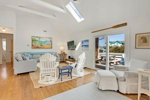 un salon avec des meubles blancs et un patio dans l'établissement 3040 - SeaVue, à Southern Shores