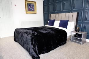 a bedroom with a large bed with blue walls at Kenley Hotel in Blackpool +22 photos