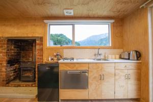 a kitchen with a sink and a window and a stove at Mataura River Hideaway in Ardlussa