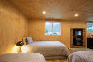 a bedroom with two beds and a tv in it at Mataura River Hideaway in Ardlussa