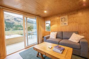 a living room with a couch and a table at Mataura River Hideaway in Ardlussa