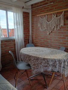 a table and chairs in a room with a brick wall at Cabañas Don Fernando in Santa Rosa de Calamuchita +74 photos