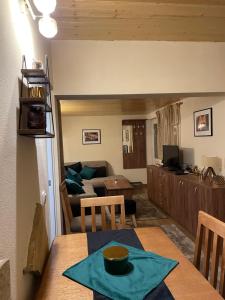 eine Küche und ein Wohnzimmer mit einem Tisch mit einer Schüssel darauf in der Unterkunft Planinska kuca ANDJELA 2 in Mitrovac