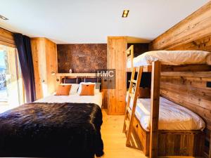 2 stapelbedden in een kamer met houten wanden bij Chalet Bliss Jacuzzi vue in Bolquere Pyrenees 2000