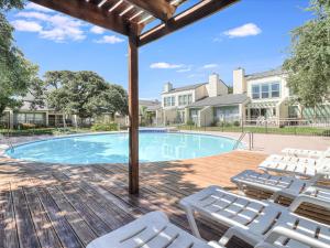a swimming pool with white chairs and a deck at Adventure House RRYC17 in Rockport