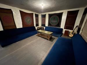 une pièce avec des canapés bleus et une table dans l'établissement Intihuatana Hostel, à Pisac