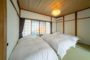 Ένα ή περισσότερα κρεβάτια σε δωμάτιο στο 家族旅館四国周遊元山