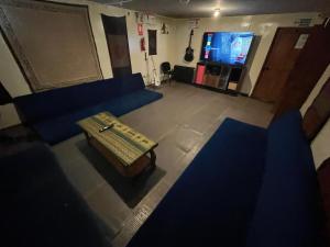 un salon avec un canapé bleu et une table basse dans l'établissement Intihuatana Hostel, à Pisac 117 autres photos