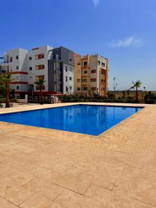 a large swimming pool in front of some buildings at Vue imprenable sur mer in Tangier