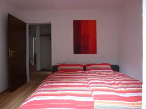 ein Bett mit zwei roten Kissen in einem Schlafzimmer in der Unterkunft Ferienpark Oberallgäu Ferienwohnung in Missen-Wilhams