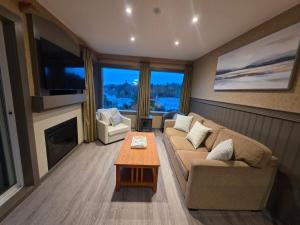 un soggiorno con un divano e un tavolo di Oceanside GetAway at Pacific Shores a Nanoose Bay