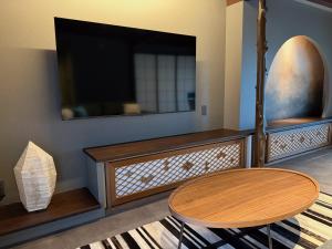 un soggiorno con tavolo e TV a schermo piatto di SORAIRO Miyajima a Hatsukaichi