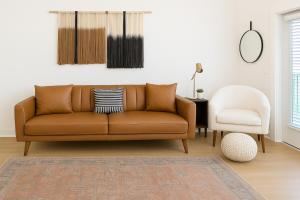 a living room with a brown couch and a white chair at Worker friendly A plus Location Warm and Cozy in Sherman