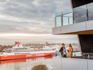 a couple standing on the balcony of a cruise ship at Novotel Devonport in Devonport