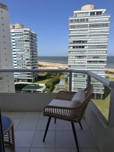 een balkon met een stoel en uitzicht op de oceaan bij Apto Punta del Este stop 4 playa brava in Punta del Este