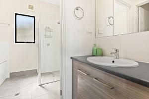 CarrickalingaにあるOcean Heights - 27 Stacey Driveの洗面台とシャワー付きの白いバスルーム