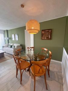 een eetkamer met een glazen tafel en stoelen bij Apto Punta del Este stop 4 playa brava in Punta del Este