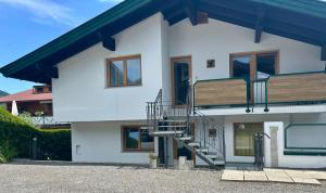 Hannes Appartement in im Zentrum von Kirchberg - by NV-Appartements في كيرشبرغ ان تيرول: بيت ابيض فيه درج وبلكونه