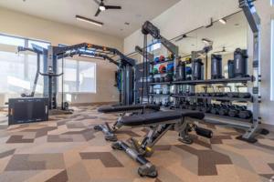a gym with several tread machines in a room at WorkerFriendly KINGbed A plus Location Washer Wifi Pool in Sherman