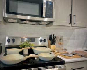 a kitchen with three bowls on a counter with a microwave at WorkerFriendly KINGbed A plus Location Washer Wifi Pool in Sherman