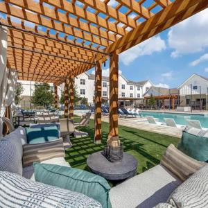 a patio with couches and chairs under a pergola at WorkerFriendly washer dryer gym pool A plus location in Sherman