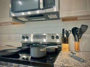 a kitchen with a stove top with pots and pans at WorkerFriendly washer dryer gym pool A plus location in Sherman +4 photos
