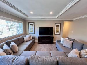 een woonkamer met twee banken en een flatscreen-tv bij Destination #32 in Anaheim