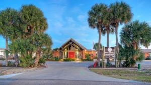 阿兰瑟斯港Walk to Alister St Near Dining King Suite w Private Yard Fire Pit Casa Santori by AvantStay的一座前面有棕榈树的建筑