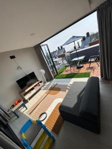 Una sala de estar con un sofá y una ventana grande. en NZ Villa Guesthouse Aesthetic Batu, en Malang