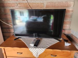 een televisie op een tafel met afstandsbediening bij Canto do Luar in Santa Cruz do Sul