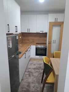 a kitchen with white cabinets and a table and chairs at Apartment Lara in Mostar