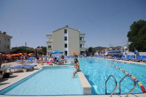 a woman standing in a swimming pool at a resort at Candan Apart in Marmaris