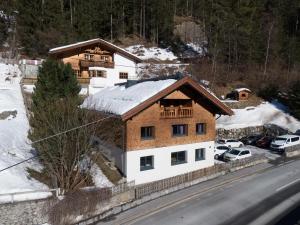 a house on the side of a road with snow at Apart Loisa in Pettneu am Arlberg