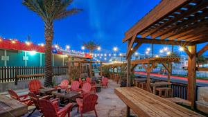 a restaurant with wooden tables and chairs and a beach at Modern Coastal Home w Balcony Views Firepit Prime Port A Location Casa Blanca by AvantStay in Port Aransas
