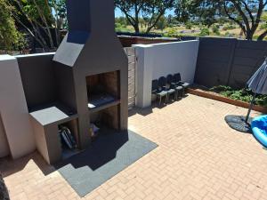 a outdoor fireplace on a patio with two chairs at 35 Amanda - Durbanville in Cape Town