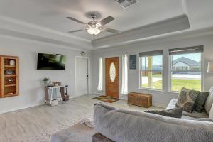 a living room with a couch and a ceiling fan at A Wave From It All in Rockport